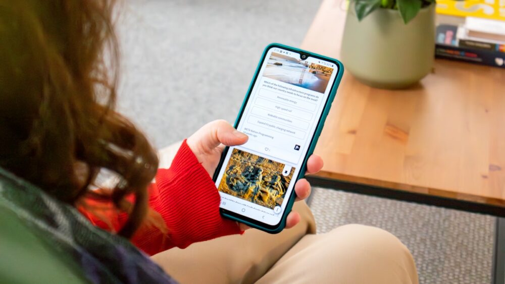 ソファに座ってスマートフォンを見る女性