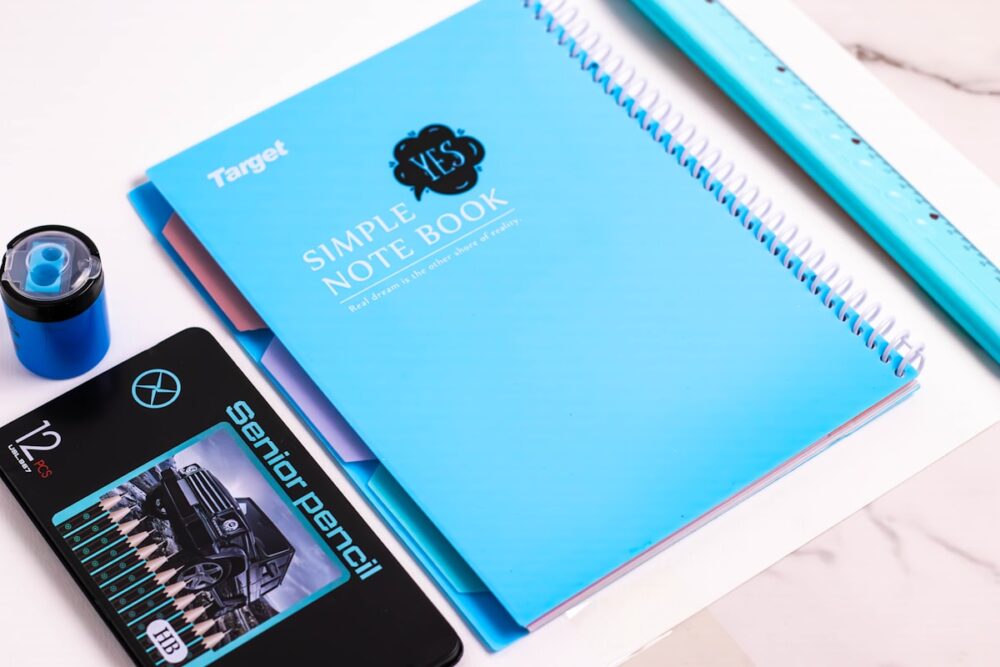 タブレットで英語レッスンを受けながらノートを取る学生