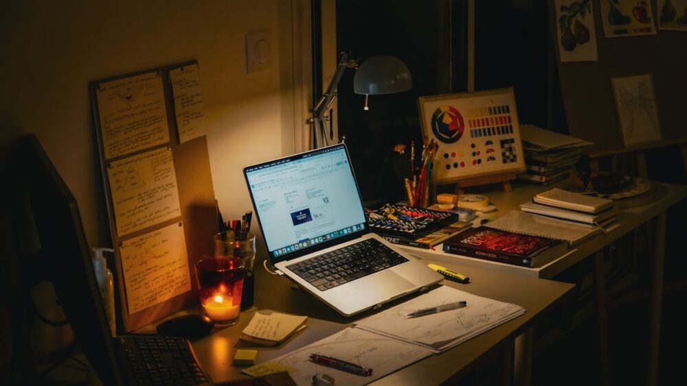 夜にノートとパソコンで集中して勉強する様子