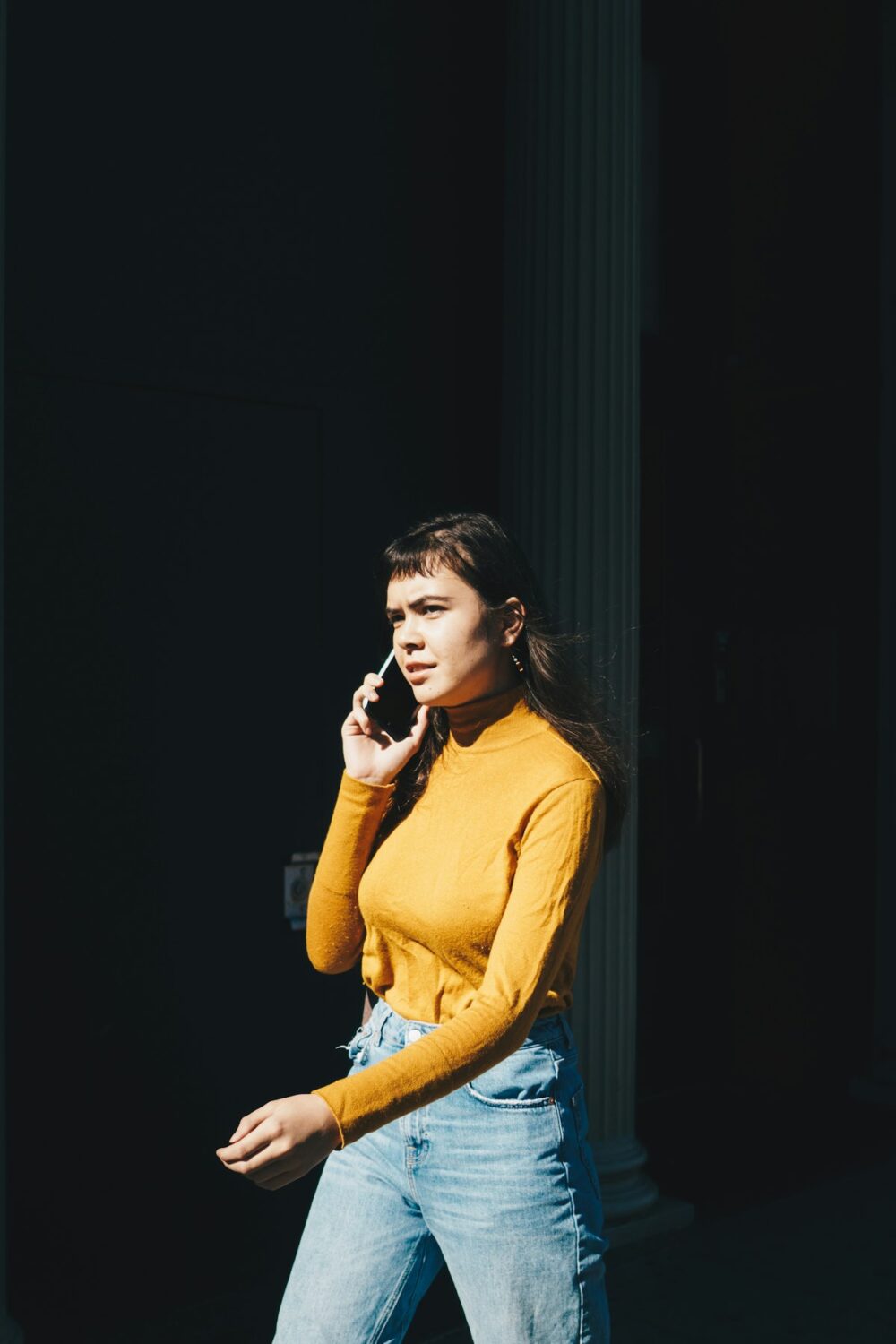 ヘッドホンをつけてスマホで音声会話をする女性