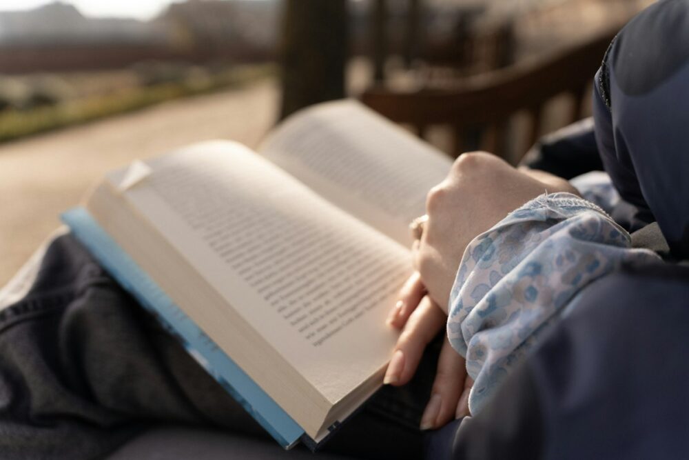 AIグラスをかけながら外で読書や単語調べをするイメージ