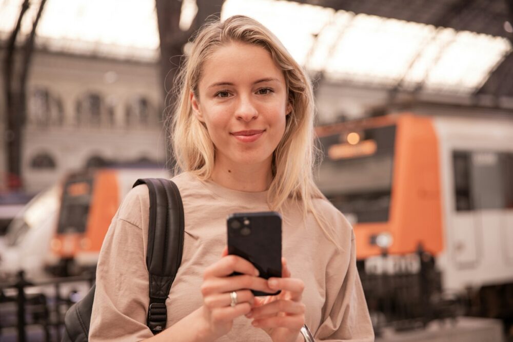 海外の駅でスマホの通訳アプリを使うイメージ