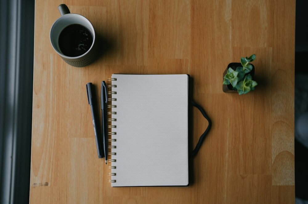 ノートとコーヒーで毎日の学習計画を立てるイメージ
